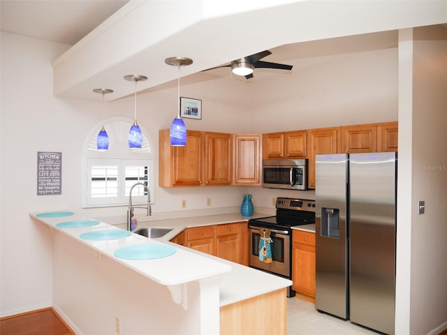 kitchen with kitchen peninsula, stainless steel appliances, ceiling fan, sink, and pendant lighting