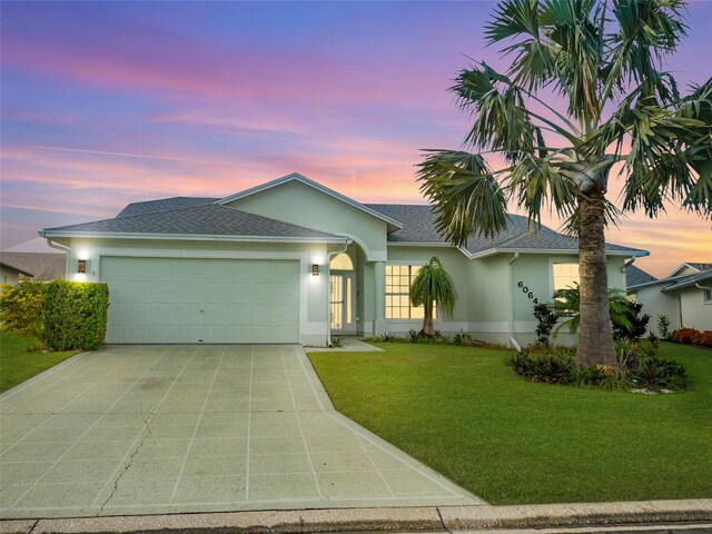 single story home with a yard and a garage