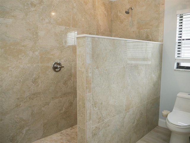 bathroom with toilet and tiled shower