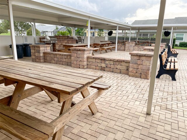 view of patio / terrace featuring grilling area, a bar, and an outdoor kitchen