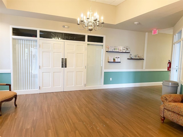 foyer featuring hardwood / wood-style floors and an inviting chandelier