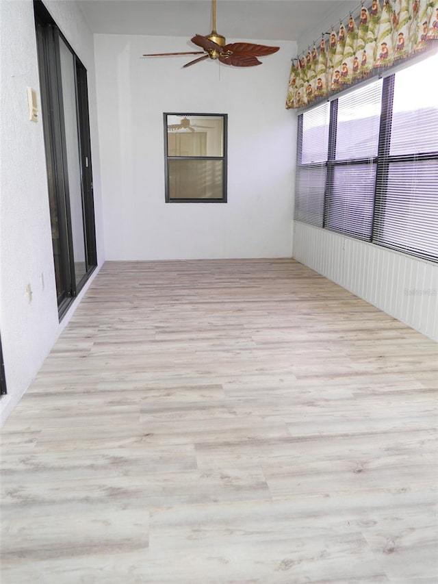 unfurnished sunroom with ceiling fan