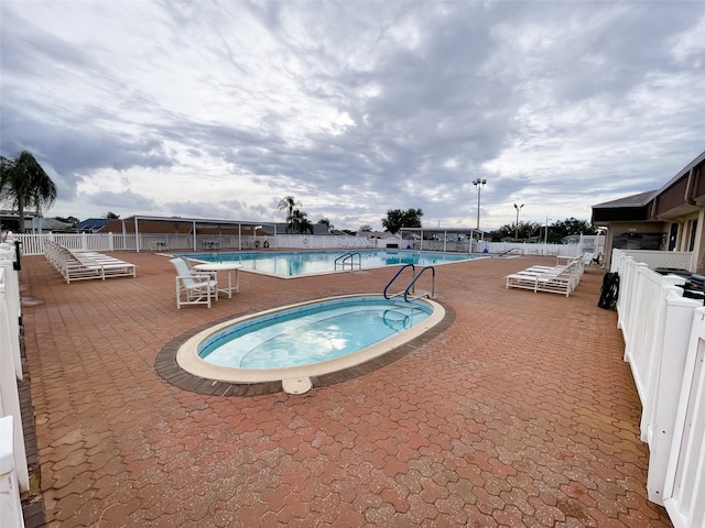 view of pool with a community hot tub and a patio