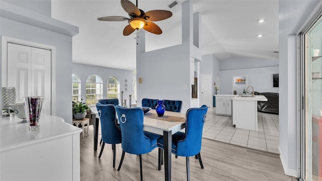 dining room with light wood-type flooring, ceiling fan, and lofted ceiling