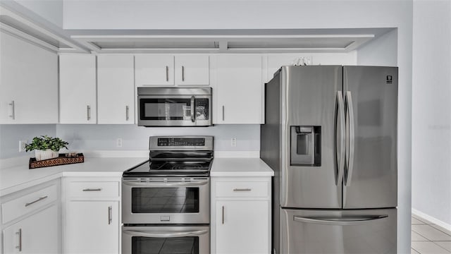 kitchen with white cabinets, stainless steel appliances, and light tile patterned flooring