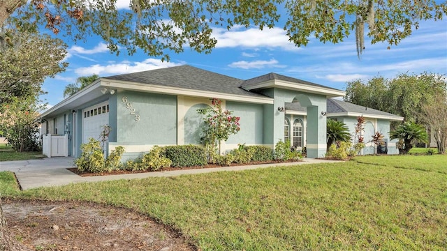 ranch-style house featuring a garage and a front lawn