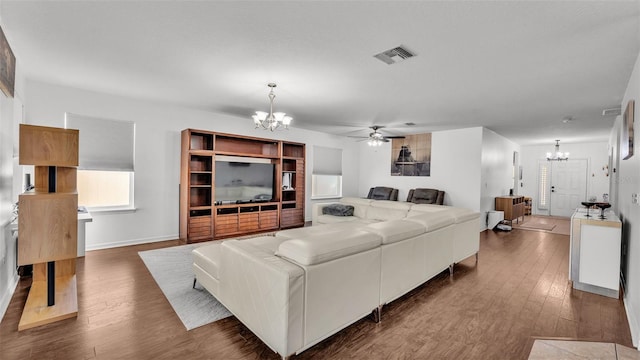 living room featuring ceiling fan with notable chandelier and dark hardwood / wood-style floors