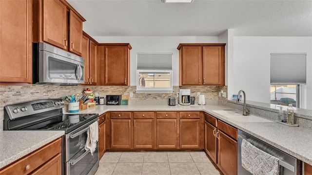 kitchen with appliances with stainless steel finishes, light countertops, and a sink