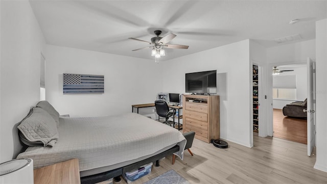 bedroom featuring visible vents, baseboards, light wood-type flooring, and ceiling fan