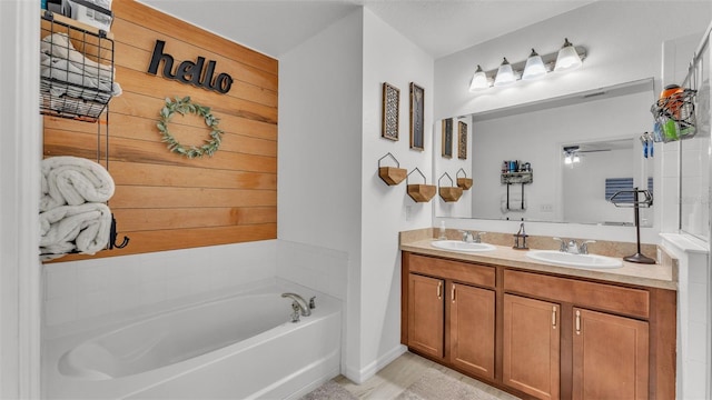 bathroom with ceiling fan, vanity, and a bath