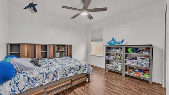 bedroom featuring ceiling fan, baseboards, and wood finished floors