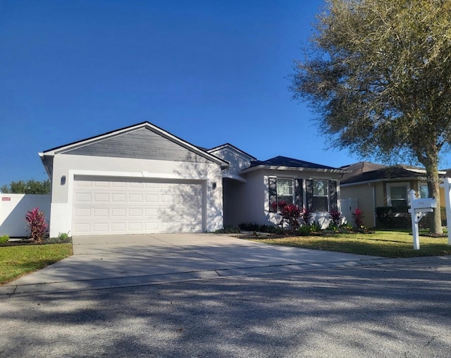 ranch-style home featuring stucco siding, driveway, an attached garage, and a front lawn