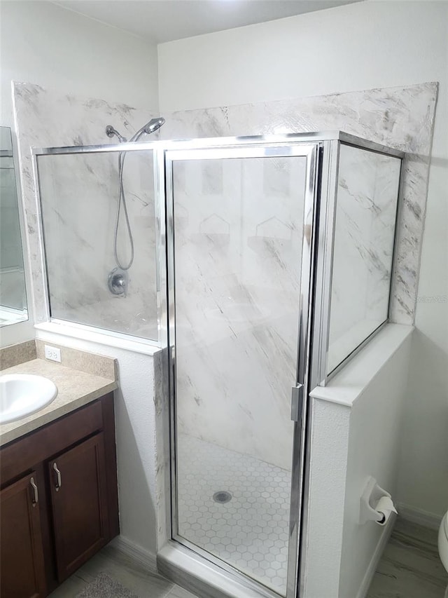 bathroom with vanity, toilet, and a marble finish shower