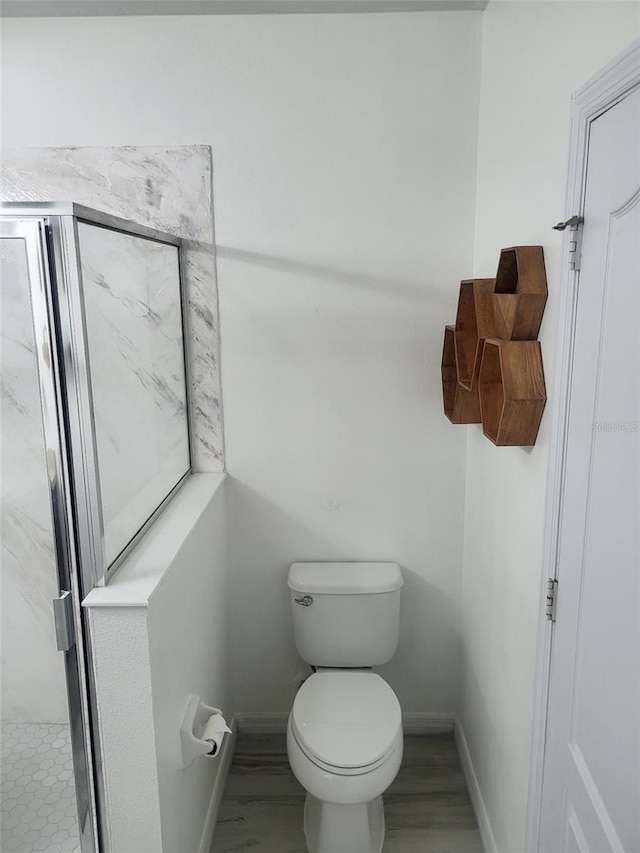 bathroom featuring toilet and baseboards