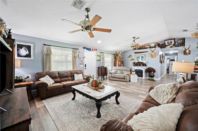 living room featuring vaulted ceiling, ceiling fan, and light hardwood / wood-style floors