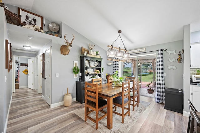 dining area featuring lofted ceiling and light hardwood / wood-style floors