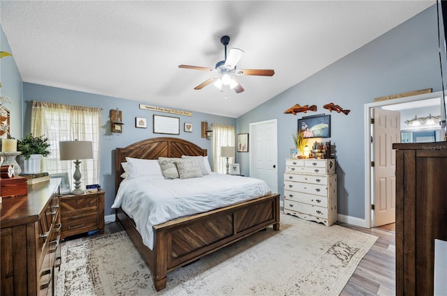 bedroom featuring lofted ceiling, ceiling fan, and light wood-type flooring