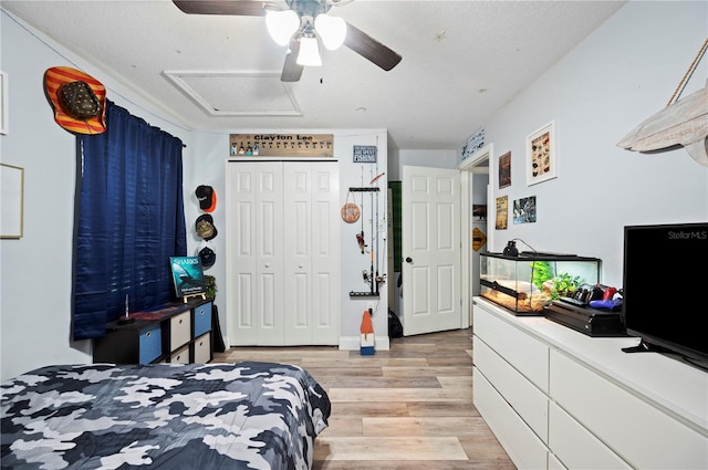 bedroom with ceiling fan, a textured ceiling, a closet, and light wood-type flooring