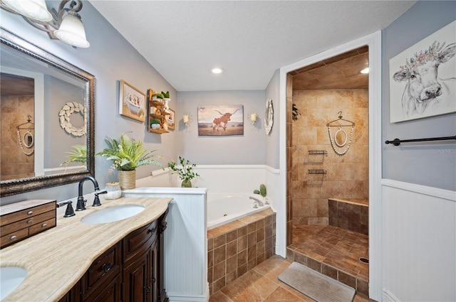 bathroom featuring vanity, plus walk in shower, tile patterned flooring, and a textured ceiling