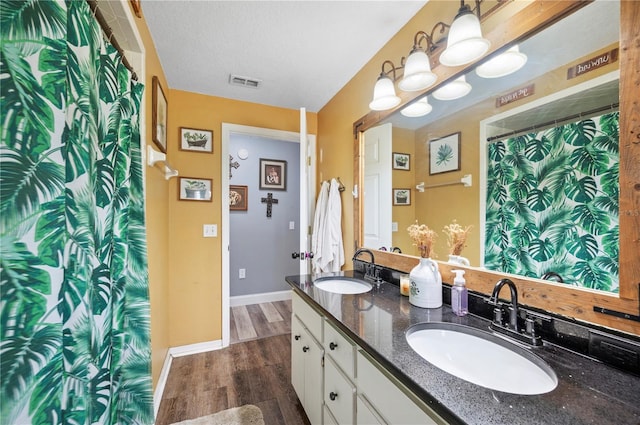 bathroom featuring vanity, hardwood / wood-style floors, and a textured ceiling