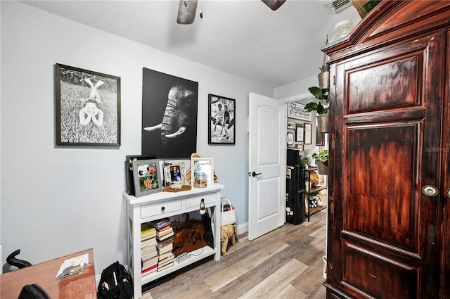 interior space with a textured ceiling and light wood-type flooring