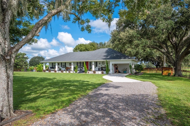 ranch-style home with a porch, a carport, and a front lawn