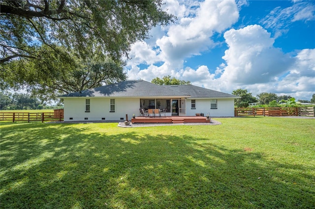 back of property featuring a deck and a lawn