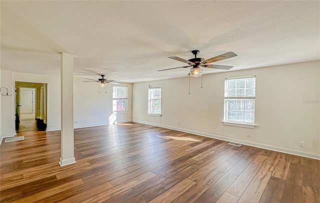 spare room featuring ceiling fan, dark wood-type flooring, and a textured ceiling