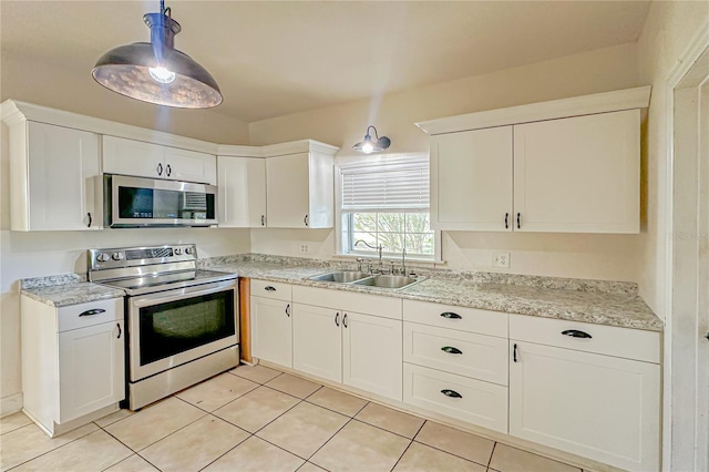 kitchen with sink, white cabinetry, stainless steel appliances, and light tile patterned floors