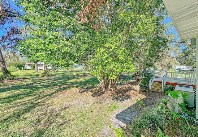 view of yard featuring central AC and a deck