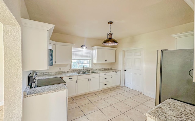 kitchen with sink, hanging light fixtures, light tile patterned flooring, white cabinetry, and stainless steel appliances