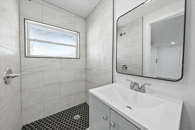 bathroom featuring vanity and tiled shower