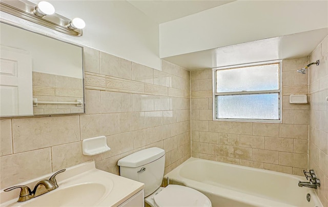 full bathroom featuring vanity, tiled shower / bath combo, toilet, and tile walls