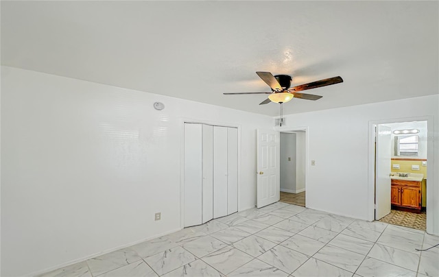 unfurnished bedroom with a closet, ensuite bath, and ceiling fan