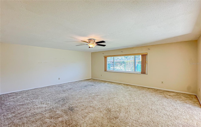 carpeted empty room featuring ceiling fan and a textured ceiling