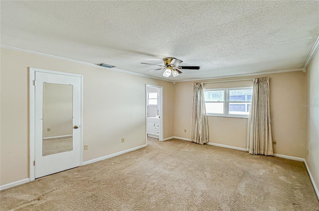 carpeted empty room featuring a textured ceiling, ceiling fan, and crown molding