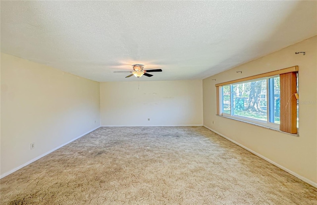 carpeted spare room featuring a textured ceiling and ceiling fan