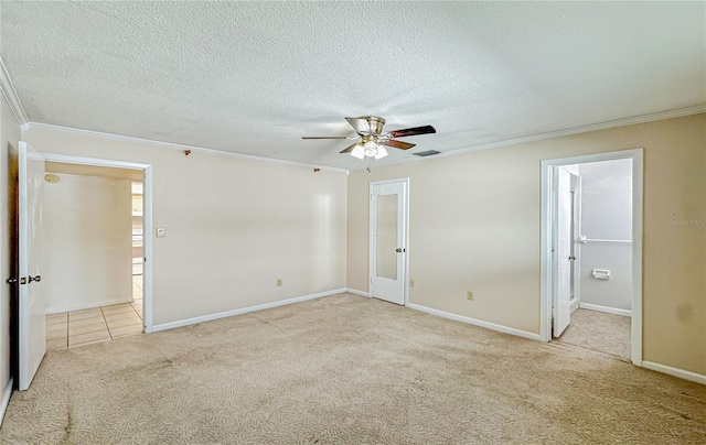 spare room featuring a textured ceiling, light colored carpet, ceiling fan, and ornamental molding