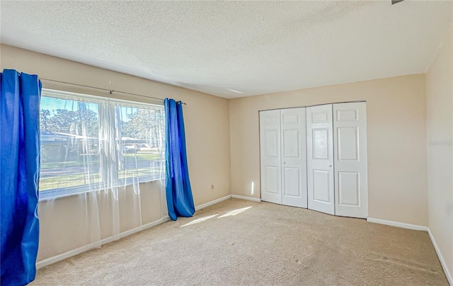 unfurnished bedroom with carpet, a textured ceiling, and a closet