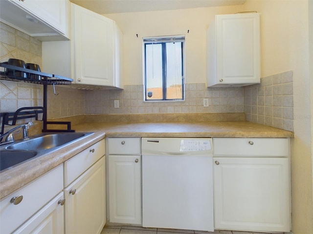 kitchen featuring white dishwasher, sink, white cabinetry, and tasteful backsplash