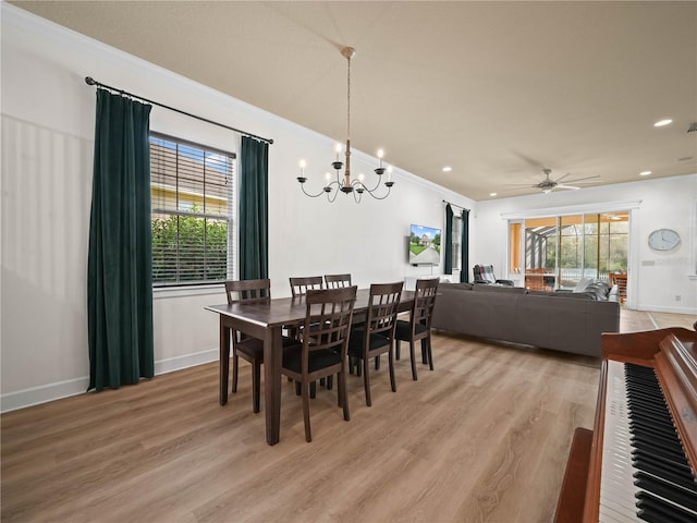 dining space with ceiling fan with notable chandelier, light wood-type flooring, and ornamental molding