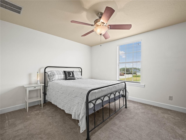 bedroom with carpet flooring, ceiling fan, and a textured ceiling