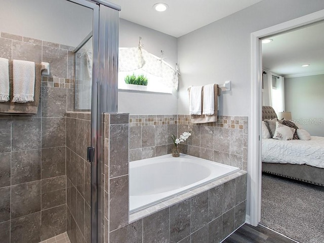 bathroom featuring wood-type flooring and shower with separate bathtub