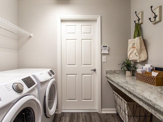 clothes washing area with washing machine and clothes dryer and dark wood-type flooring