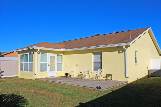 rear view of house featuring a yard, a patio, and central air condition unit