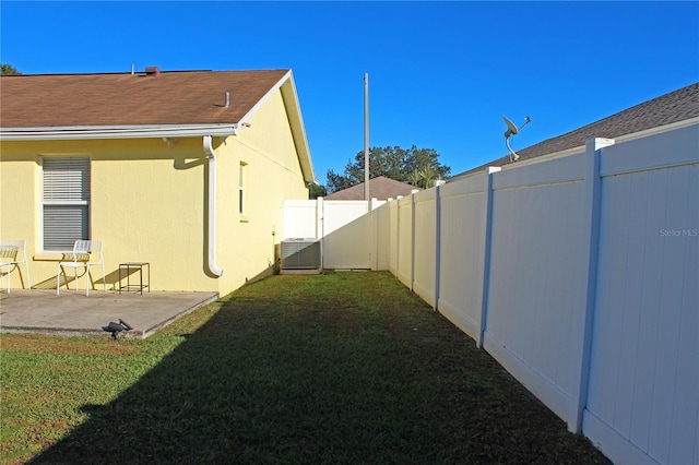 view of yard with central air condition unit and a patio