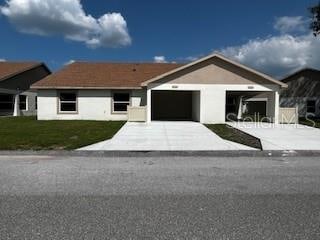 ranch-style home with a garage and a front yard