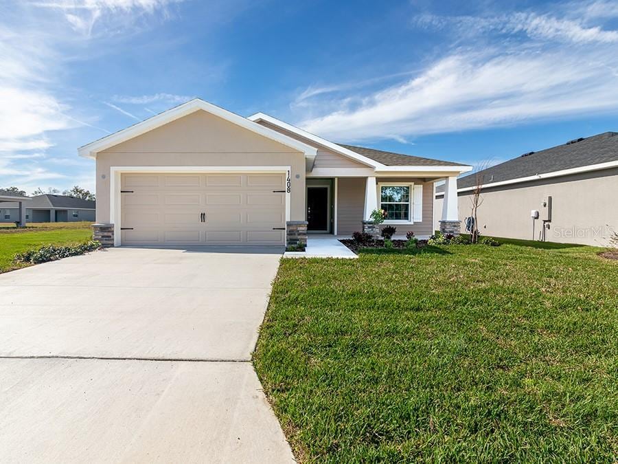 view of front of property with a front yard and a garage