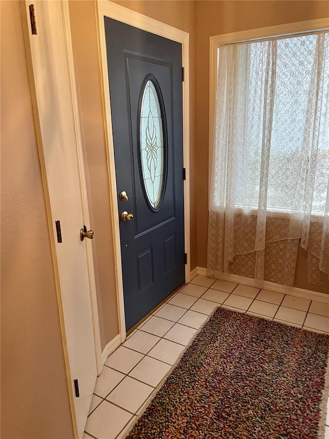 entrance foyer with light tile patterned floors and a wealth of natural light