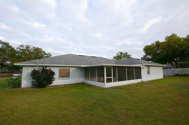 back of property with a sunroom and a yard